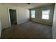A carpeted bedroom with neutral walls and two windows at 235 Hibiscus St, Winter Haven, FL 33881
