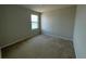Bright bedroom features neutral carpet, paint, and natural light from a single window at 235 Hibiscus St, Winter Haven, FL 33881