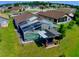 Aerial view of a backyard with a screened in pool, patio furniture, and lush green grass at 2376 Flamingo Lakes Dr, Kissimmee, FL 34743