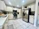 Kitchen featuring white cabinetry, stainless appliances, sleek countertops and tiled floor, perfect for cooking and entertaining at 2376 Flamingo Lakes Dr, Kissimmee, FL 34743