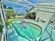 Inviting screened-in pool with blue water, lounge area, and lush landscaping, perfect for outdoor enjoyment at 2376 Flamingo Lakes Dr, Kissimmee, FL 34743