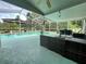 Covered outdoor living space with comfortable seating near a screened-in pool at 2376 Flamingo Lakes Dr, Kissimmee, FL 34743