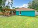 Back of turquoise home with wooden deck and large grassy lawn at 2545 El Portal Ave, Sanford, FL 32773