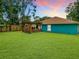 Home exterior with wooden deck, lawn and colorful sunset sky at 2545 El Portal Ave, Sanford, FL 32773