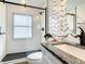 Modern bathroom featuring subway tile walls, a black-framed glass shower, and patterned accent wall at 2545 El Portal Ave, Sanford, FL 32773