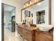 Bathroom featuring double vessel sinks and a mirror, with an open doorway to the bedroom at 2545 El Portal Ave, Sanford, FL 32773
