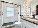 Modern bathroom features black hardware, designer wallpaper, and glass enclosed shower at 2545 El Portal Ave, Sanford, FL 32773