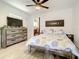 Bright bedroom with a moon phases art piece, a wooden bed frame, and a weathered dresser at 2545 El Portal Ave, Sanford, FL 32773