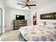 Bright bedroom featuring a rustic wood dresser, modern fan, wood-look tile flooring, and patterned bedding at 2545 El Portal Ave, Sanford, FL 32773