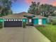 Charming turquoise home featuring a well-kept lawn, a dark grey garage door, and a cozy front porch at 2545 El Portal Ave, Sanford, FL 32773