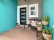 Inviting front porch featuring an iron bench with pillows, a decorative lantern, and potted snake plants at 2545 El Portal Ave, Sanford, FL 32773