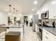 Bright, open kitchen featuring granite countertops, an island with seating, and stainless steel appliances for seamless cooking at 2545 El Portal Ave, Sanford, FL 32773