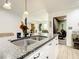 Stylish kitchen island with granite countertops, stainless steel sink, and views of the dining room and living area at 2545 El Portal Ave, Sanford, FL 32773