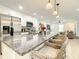 Bright kitchen boasts granite countertops, island with seating, white cabinets, and stainless steel appliances for modern cooking at 2545 El Portal Ave, Sanford, FL 32773