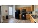 Functional kitchen with light wood cabinets, black appliances, and modern flooring at 2706 Camaro Dr, Kissimmee, FL 34746