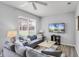 Bright living room featuring a gray sofa, ceiling fan, and a TV, creating a cozy and inviting atmosphere at 2706 Camaro Dr, Kissimmee, FL 34746