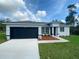 Charming single Gathering home featuring a dark garage door, inviting walkway and well-manicured lawn at 2837 Sw 173Rd Street Rd, Ocala, FL 34473