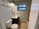 This cozy bathroom features tiled floors, storage, and a window for natural light at 285 W 2Nd St, Chuluota, FL 32766