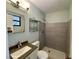 Updated bathroom featuring a modern shower with gray tile, and granite vanity top at 285 W 2Nd St, Chuluota, FL 32766