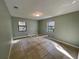 Bright empty bedroom with two windows, tile floors, and a bed frame at 285 W 2Nd St, Chuluota, FL 32766