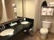Bathroom with double sinks, a toilet, and a shower/tub combo, providing essential amenities for guests at 3000 Maingate Ln # 210, Kissimmee, FL 34747