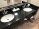 Bright bathroom featuring double sinks, granite countertops, and modern fixtures at 3000 Maingate Ln # 210, Kissimmee, FL 34747