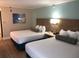 Bright hotel room with two beds, featuring light wood floors and comfortable sleeping arrangements at 3000 Maingate Ln # 210, Kissimmee, FL 34747