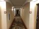 View of carpeted hallway leading to rooms, decorated with warm lighting and modern design at 3000 Maingate Ln # 210, Kissimmee, FL 34747