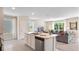 Well-lit kitchen with stainless steel dishwasher facing an open-concept living room with plush seating at 3061 Moulin Rd, Davenport, FL 33837