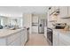 Well-lit kitchen with stainless steel appliances, white cabinets, and ample countertop space, open to the dining area at 3061 Moulin Rd, Davenport, FL 33837
