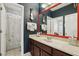 Guest bathroom with dark wood vanity, red-framed mirror, and shower/tub combo with moon and star wallpaper at 3201 Glenmere Way, Orlando, FL 32828