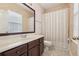 Traditional bathroom featuring a marble vanity, dark wood cabinetry, and shower/tub combo with patterned wallpaper at 3201 Glenmere Way, Orlando, FL 32828