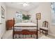 Relaxing bedroom featuring a wooden four-poster bed, and a window with decorative curtains at 3201 Glenmere Way, Orlando, FL 32828