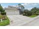 Exterior view showcasing a home's two-car garage, long driveway, and screened-in pool enclosure at 3201 Glenmere Way, Orlando, FL 32828