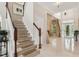 Elegant foyer with a staircase, tile flooring, and a view into the formal living area and front door at 3201 Glenmere Way, Orlando, FL 32828