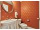 Stylish powder room featuring star wallpaper, a round mirror, elegant fixtures, and a pedestal sink at 3201 Glenmere Way, Orlando, FL 32828