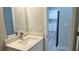 Bathroom with modern sink, a large mirror, and a doorway view to the kitchen at 3498 Sw 131St Place Rd, Ocala, FL 34473