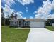 Beautiful single-story home with a well-manicured lawn and a two-car garage on a sunny day at 3498 Sw 131St Place Rd, Ocala, FL 34473