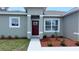 Welcoming front entrance with a red door, colorful plants, and a freshly manicured flower bed at 3498 Sw 131St Place Rd, Ocala, FL 34473