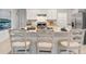 Modern kitchen island with seating, stainless steel appliances, granite countertops, and white cabinetry at 3507 Costello Cir, Winter Haven, FL 33884