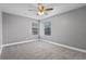 Neutral bedroom featuring carpet, ceiling fan, and two windows for natural light at 380 Lake Ontario Ct # 201, Altamonte Springs, FL 32701