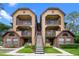 Inviting condo complex featuring multi-story buildings, beautiful landscaping, and exterior stairs at 380 Lake Ontario Ct # 201, Altamonte Springs, FL 32701