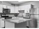 Bright kitchen with stainless steel appliances, white cabinets, and a granite countertop island at 380 Lake Ontario Ct # 201, Altamonte Springs, FL 32701