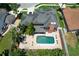 Aerial view of the property showcasing the pool, patio, lush landscaping, and roof at 383 Remington Dr, Oviedo, FL 32765