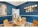 Cozy dining area featuring blue walls, wood floors, a glass table, and unique decor at 383 Remington Dr, Oviedo, FL 32765