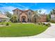 Charming two-story brick home featuring a well-manicured lawn and mature landscaping at 383 Remington Dr, Oviedo, FL 32765