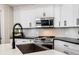 Kitchen features white cabinets, stainless steel appliances, and modern backsplash at 383 Remington Dr, Oviedo, FL 32765