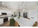 Bright kitchen boasts white cabinets, stainless appliances, large island and stylish pendant lighting at 383 Remington Dr, Oviedo, FL 32765