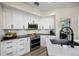 White cabinets and stainless appliances adorn this stylish and functional kitchen with black countertops at 383 Remington Dr, Oviedo, FL 32765