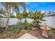 Lush landscaping featuring a fountain, banana trees, and other tropical plants along a white fence at 383 Remington Dr, Oviedo, FL 32765